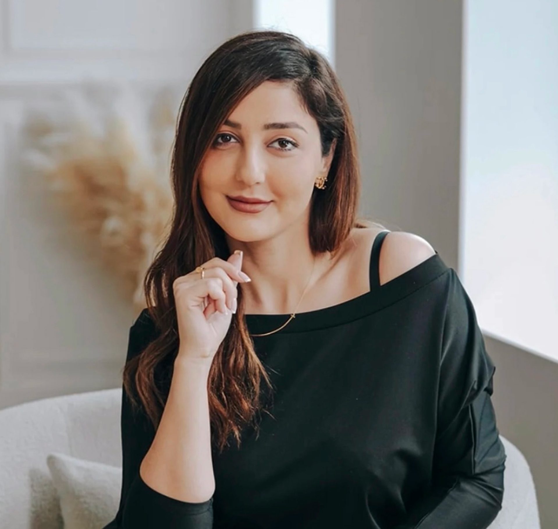 Aesthetic consultation at Dr. Owlia Aesthetics — smiling woman seated in a bright consultation room