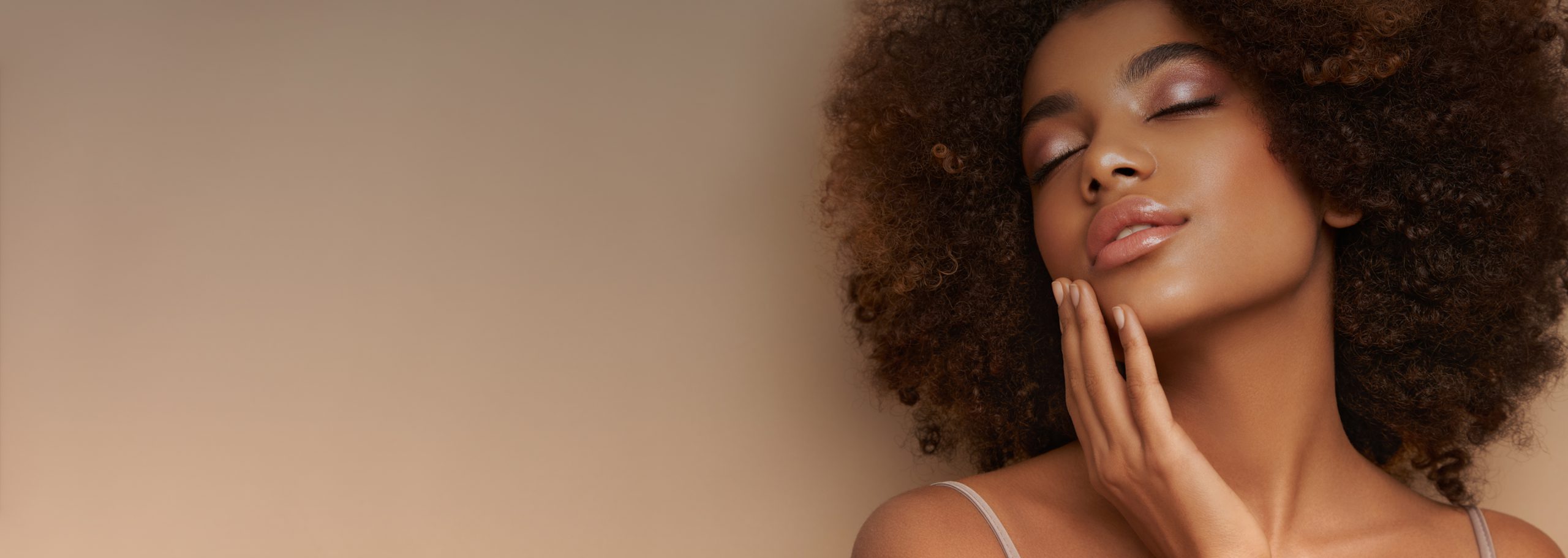 Cosmetic treatment models at Dr. Owlia Aesthetics — woman with natural curls and glowing skin